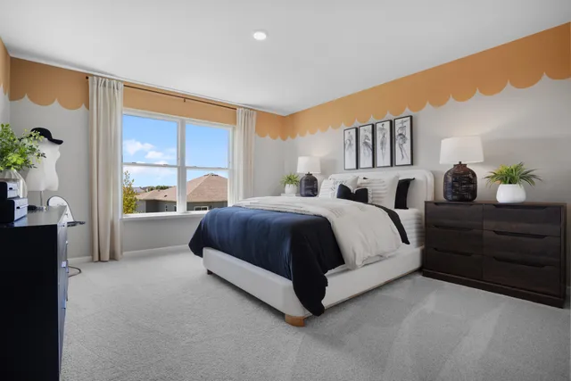 a spacious bedroom with a bed and a large window