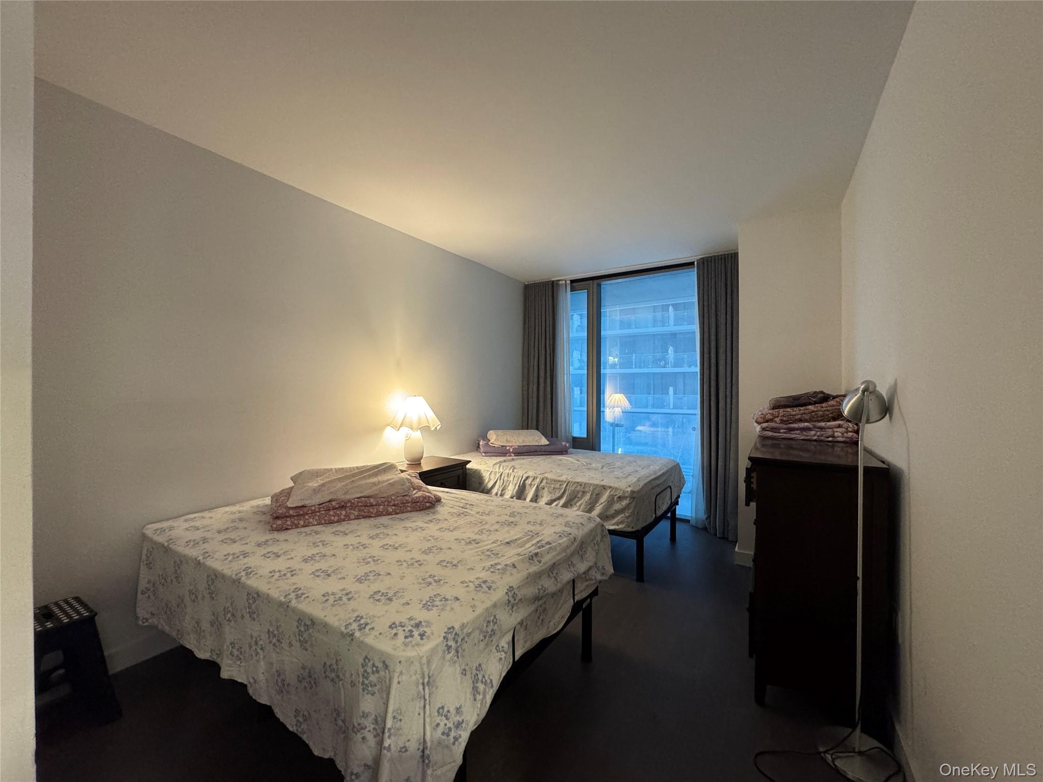 131-03 40 Road, Unit 10H Queens, NY 11354 - Photo 7 of 14 a bedroom with a bed and a table in it