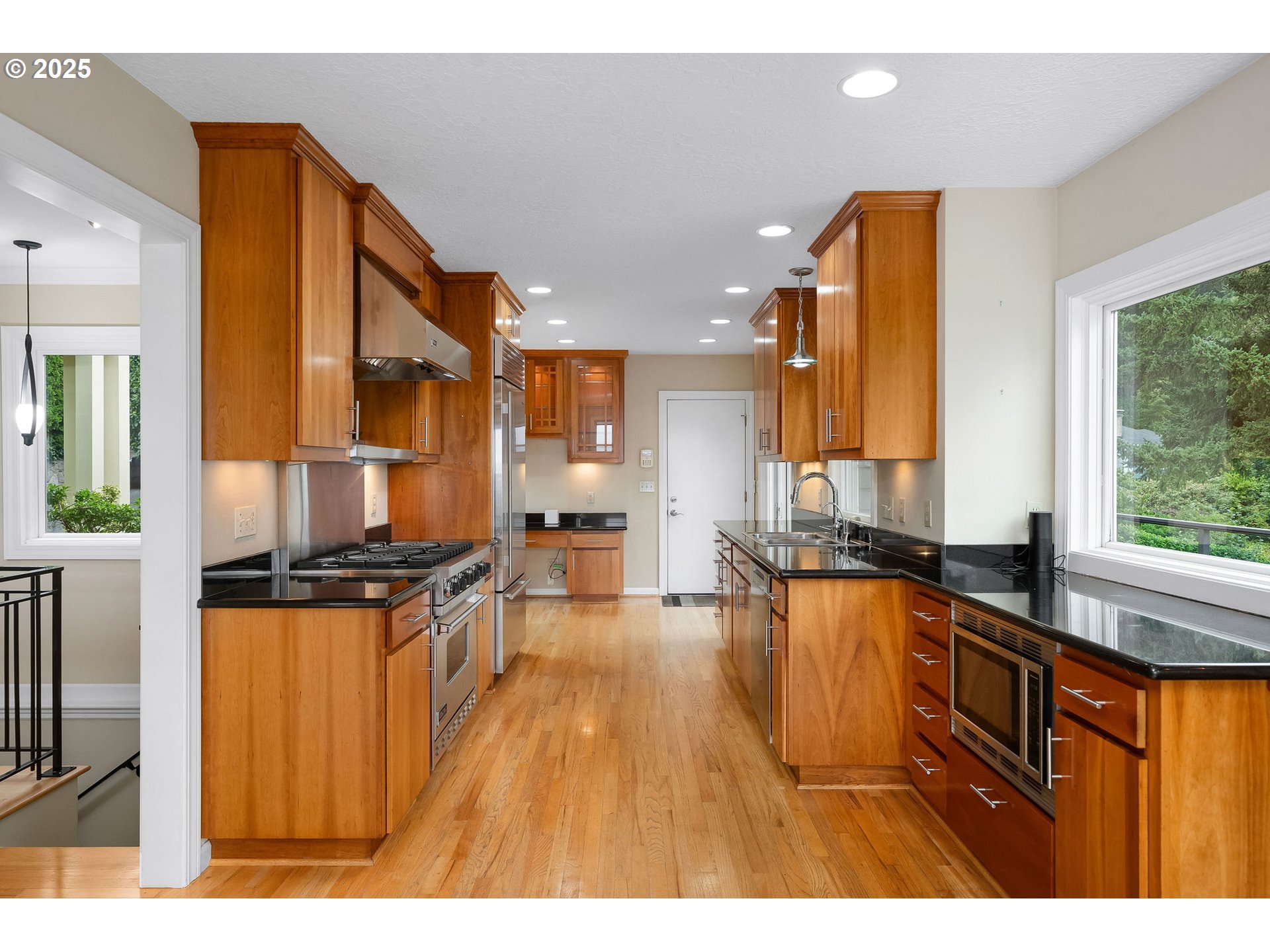 3250 Southwest Donner Way Court Portland, OR 97239 - Photo 8 of 48 a kitchen with a sink a counter top space a large window and stainless steel appliances