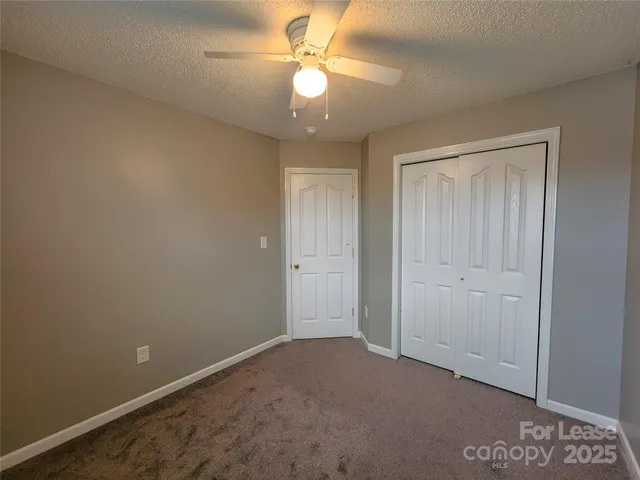 an empty room with a ceiling fan and a window
