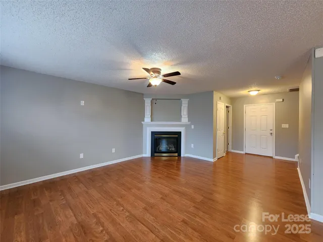 a view of an empty room with a fireplace and a window