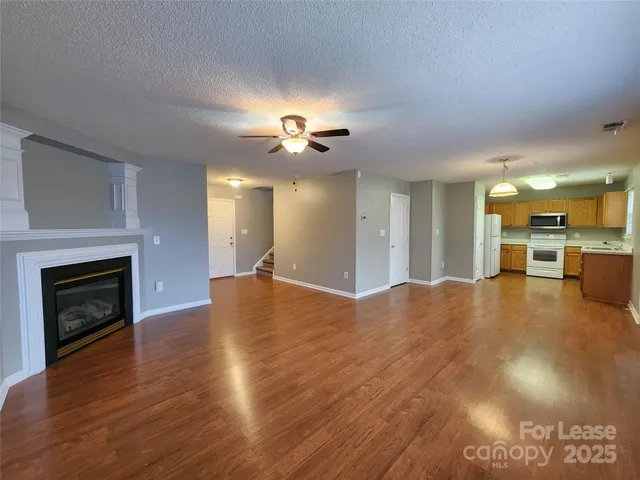 a view of an empty room with a fireplace and window