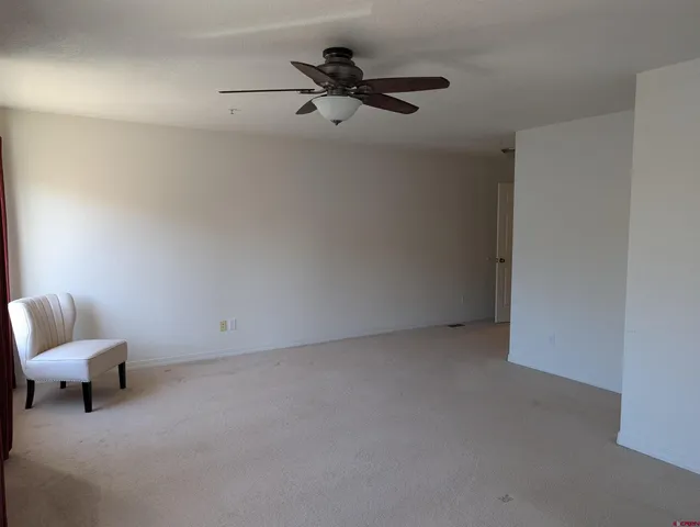 a living room with furniture and a ceiling fan