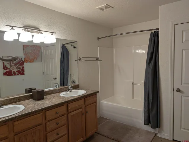 a bathroom with a granite countertop sink a mirror and a bathtub