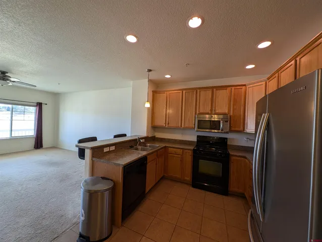 a kitchen with stainless steel appliances granite countertop a stove a refrigerator and a refrigerator