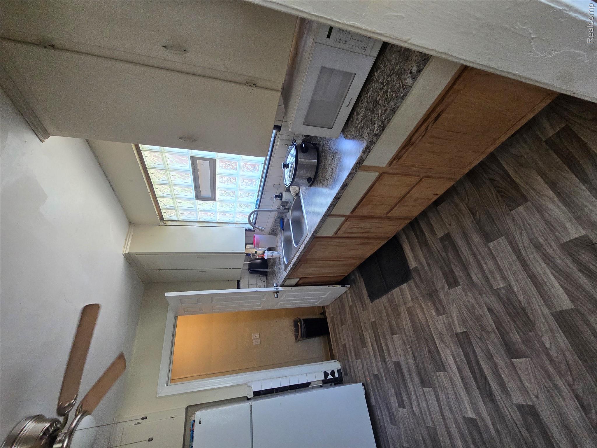 10342 Roxbury Street Detroit, MI 48224 - Photo 13 of 30 Kitchen featuring wood-finish flooring, a double basin sink, and a block glass window