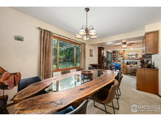 a dining room with furniture a chandelier and window