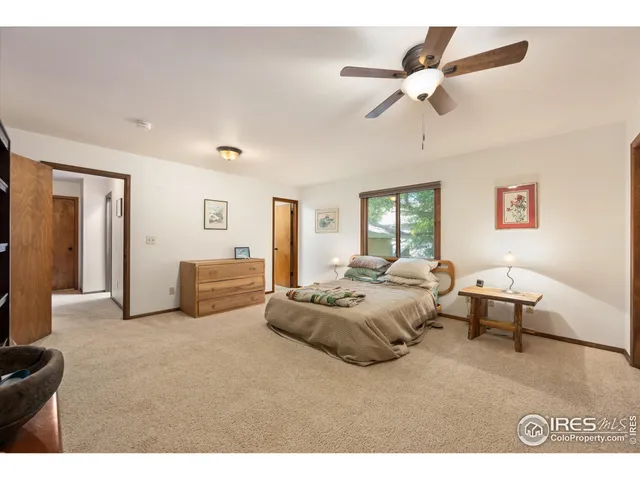 a spacious bedroom with a bed a couch and a ceiling fan
