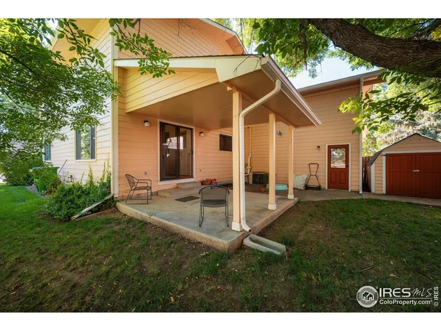 a view of a house with backyard and a tree
