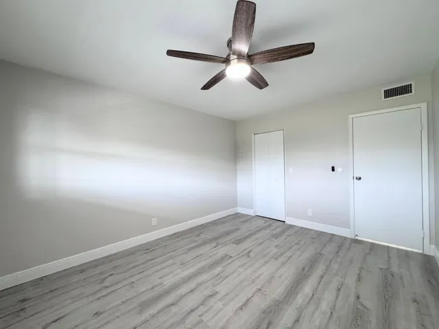 a view of an empty room with wooden floor