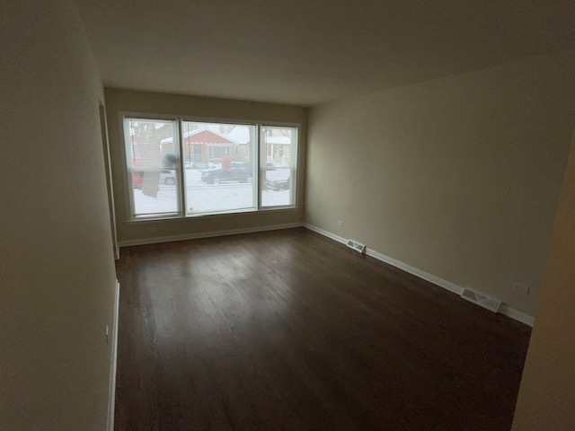 12312 South May Street Calumet Park, IL 60827 - Photo 2 of 11 an empty room with wooden floor and windows