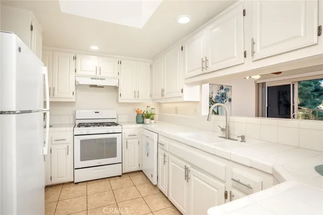 a kitchen with white cabinets and white appliances
