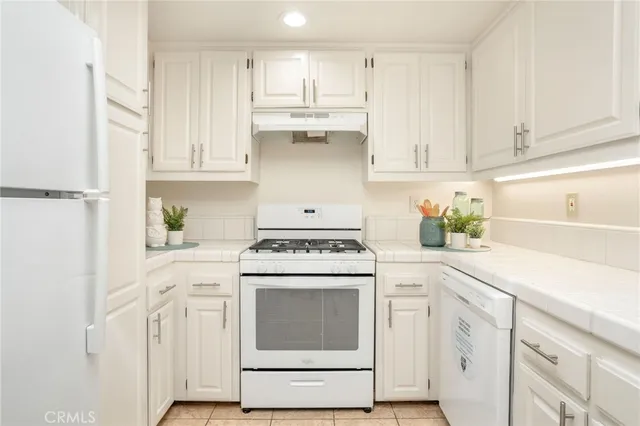 a kitchen with cabinets appliances and a sink