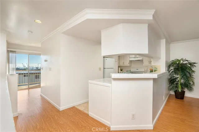 a kitchen with a sink a refrigerator and wooden floor