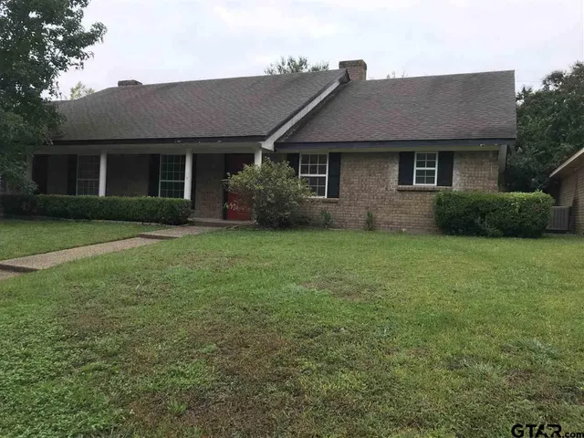 a front view of a house with a garden and yard
