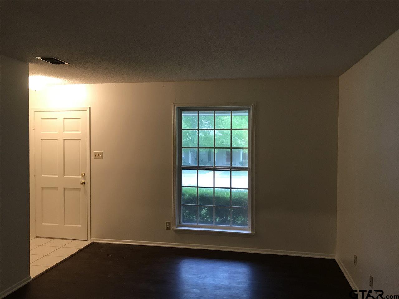 3721 Colony Park Drive Tyler, TX 75701 - Photo 3 of 11 an empty room with wooden floor and windows
