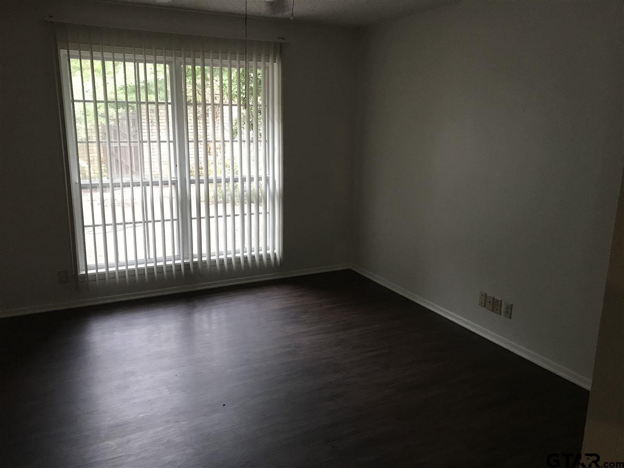 3721 Colony Park Drive Tyler, TX 75701 - Photo 5 of 11 a view of an empty room with wooden floor and a window