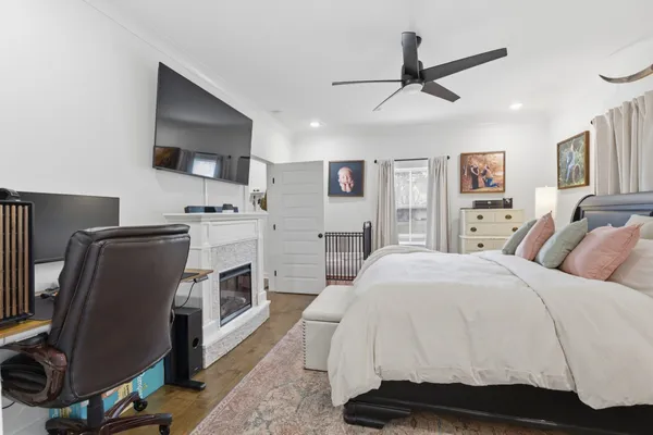 a spacious bedroom with a bed and a flat screen tv