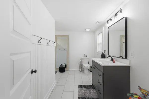 a bathroom with a sink vanity granite tub shower and a mirror