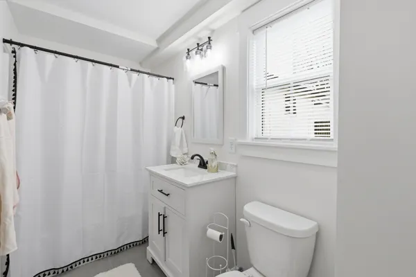 a bathroom with a sink a toilet and a window