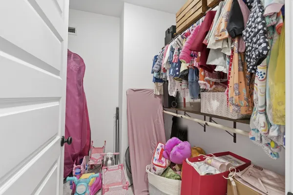 a view of walk in closet with clothes and shoes