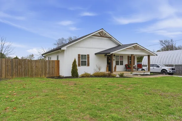 a view of a house with a yard and sitting area