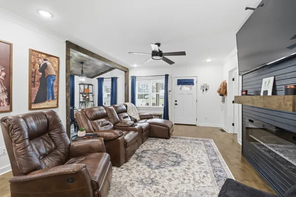 a living room with furniture a ceiling fan and a rug
