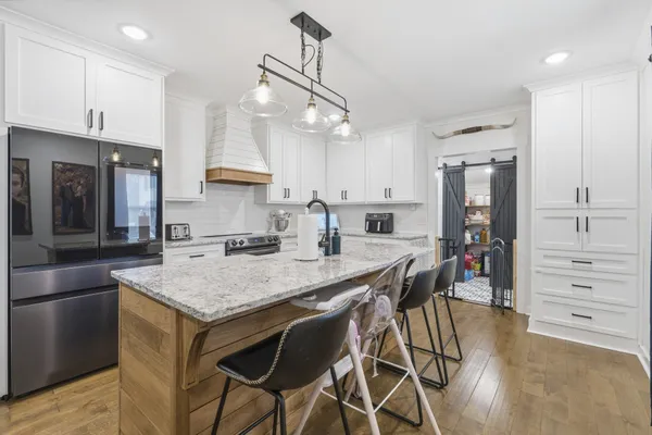 a kitchen with stainless steel appliances granite countertop a sink a stove and a refrigerator