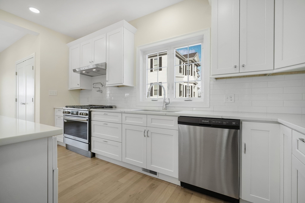 144 Bailey Street Fall River, MA 02724 - Photo 8 of 37 a kitchen with stainless steel appliances granite countertop a stove and white cabinets