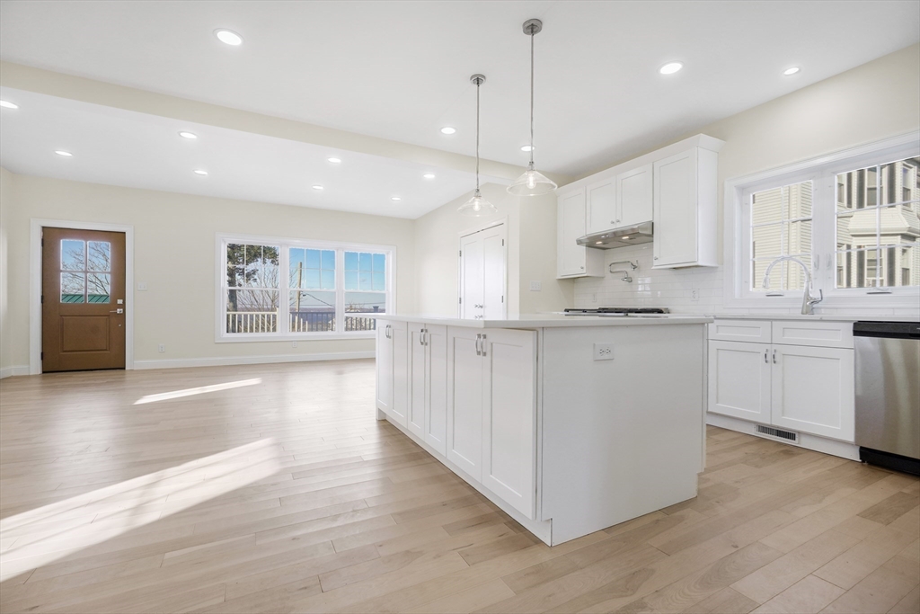 144 Bailey Street Fall River, MA 02724 - Photo 9 of 37 a large kitchen with stainless steel appliances kitchen island a large counter top and a wooden floors