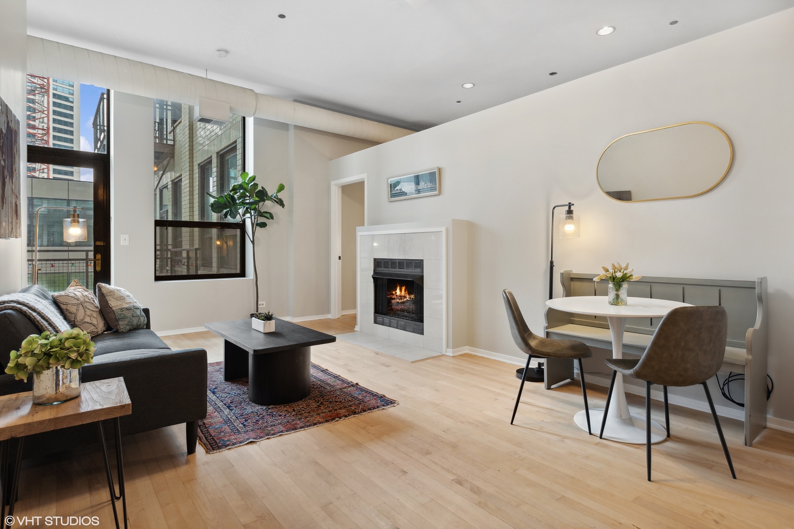 910 South Michigan Avenue, Unit 816 Chicago, IL 60605 - Photo 2 of 21 a living room with furniture a fireplace and a table