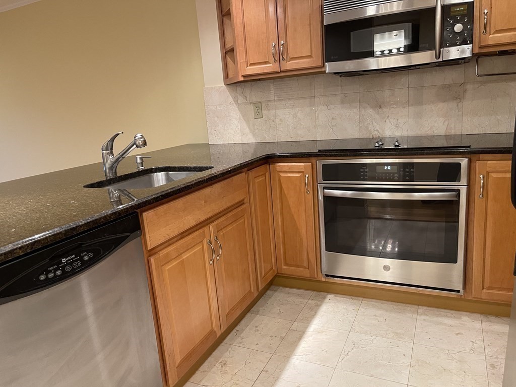 20 Webster Street, Unit 405 Brookline, MA 02446 - Photo 5 of 22 a kitchen with granite countertop cabinets and a stove top oven