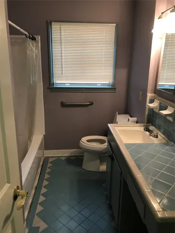 a bathroom with a sink toilet and window
