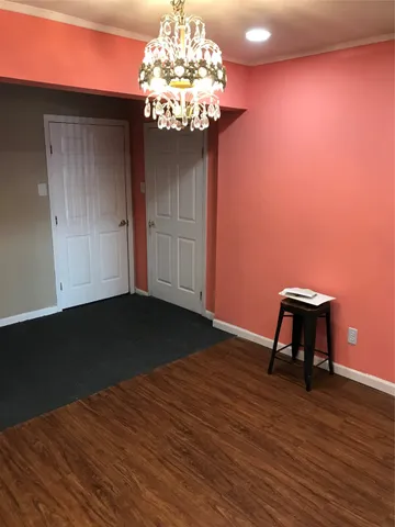 a view of a room with wooden floor and cabinets