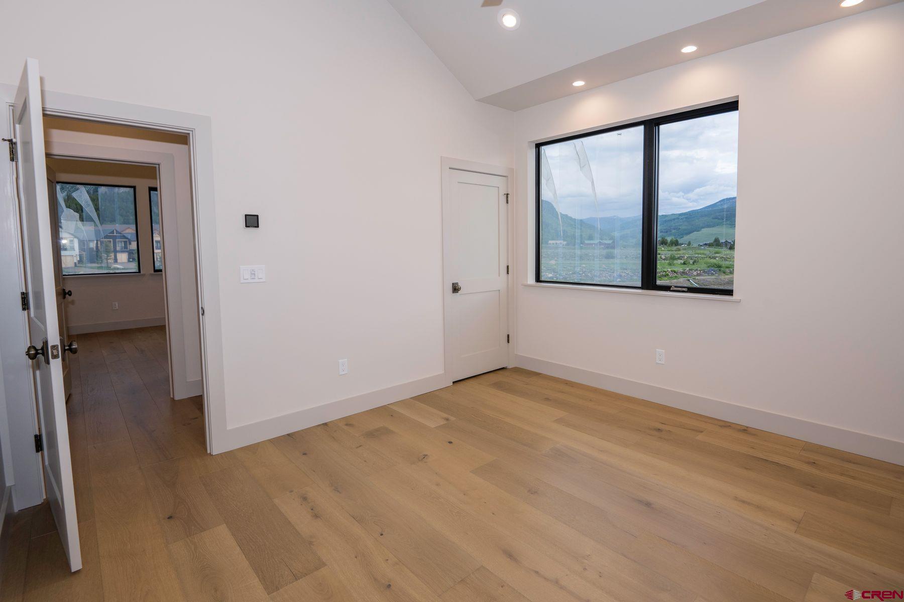 180 Elk Valley Road, Unit 107 Crested Butte, CO 81224 - Photo 16 of 35 a view of an empty room with wooden floor and a window
