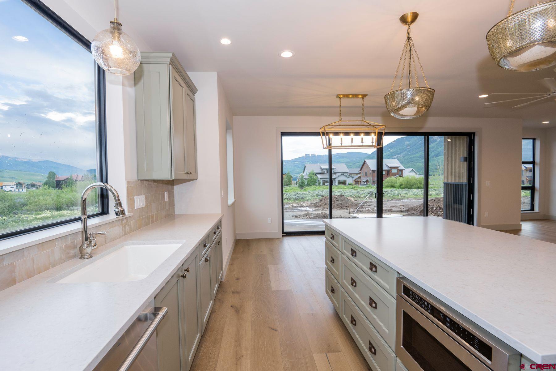 180 Elk Valley Road, Unit 107 Crested Butte, CO 81224 - Photo 2 of 35 a large kitchen with kitchen island a large counter space a large window and stainless steel appliances