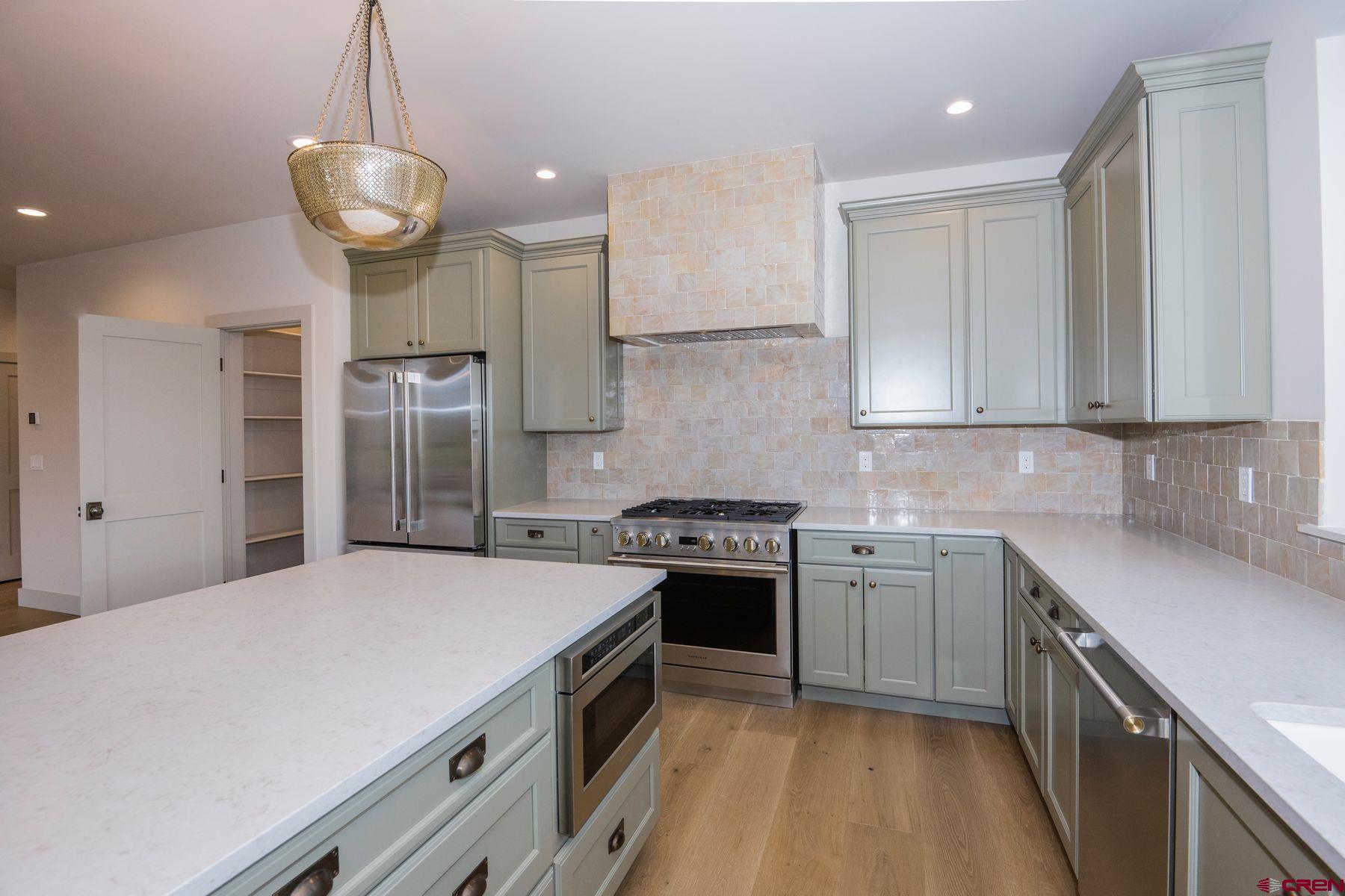 180 Elk Valley Road, Unit 107 Crested Butte, CO 81224 - Photo 3 of 35 a kitchen with a stove a sink and a refrigerator