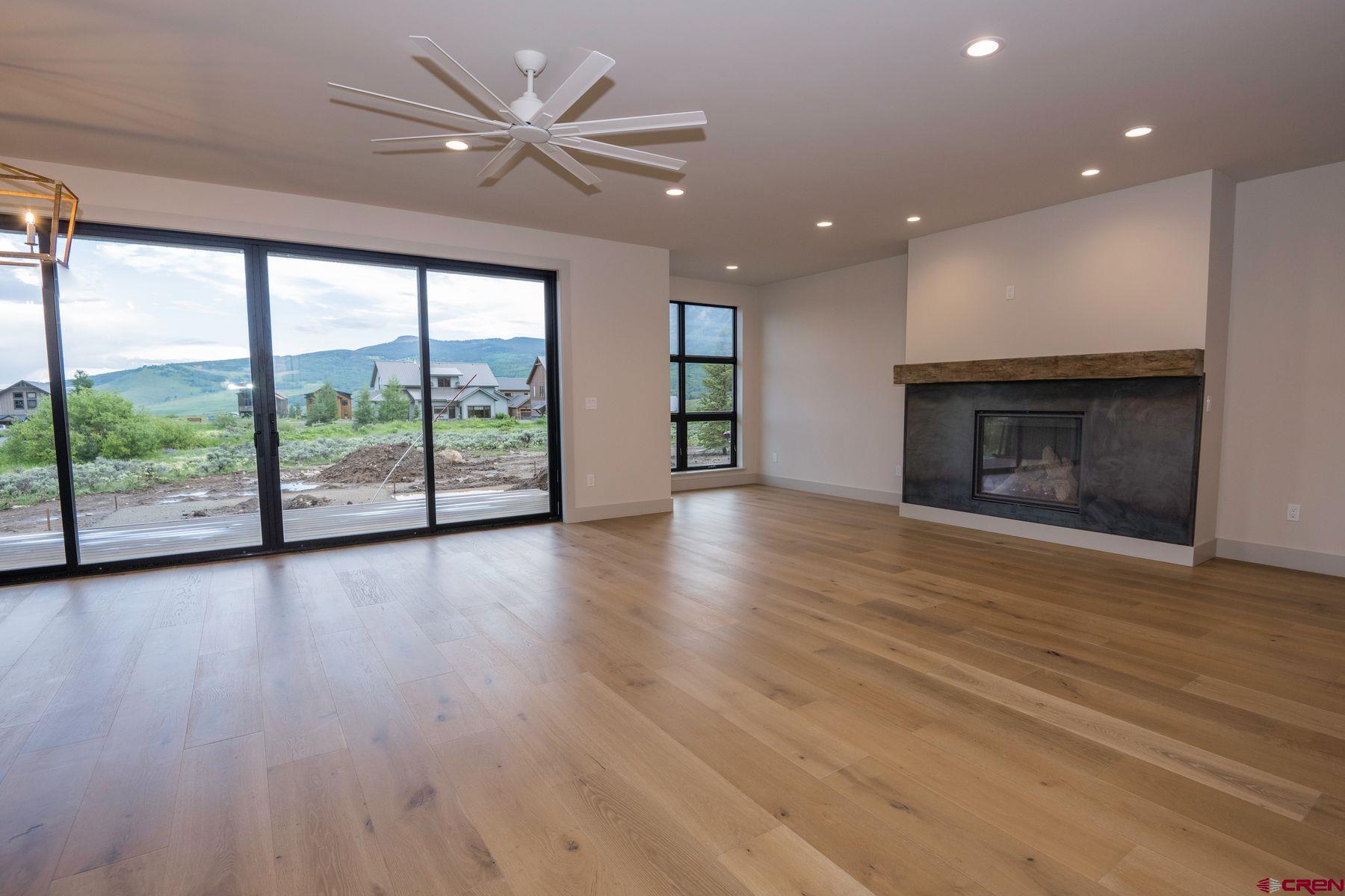 180 Elk Valley Road, Unit 107 Crested Butte, CO 81224 - Photo 8 of 35 an empty room with wooden floor fan and windows