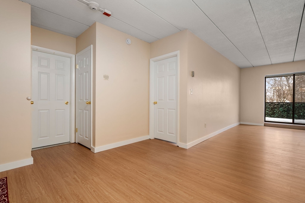 90 High Street, Unit 309 Dedham, MA 02026 - Photo 4 of 20 an empty room with wooden floor and windows
