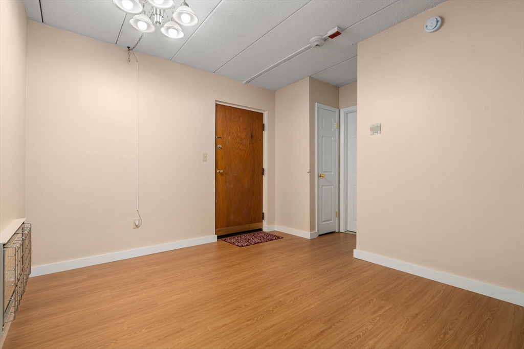 90 High Street, Unit 309 Dedham, MA 02026 - Photo 5 of 20 an empty room with wooden floor and windows