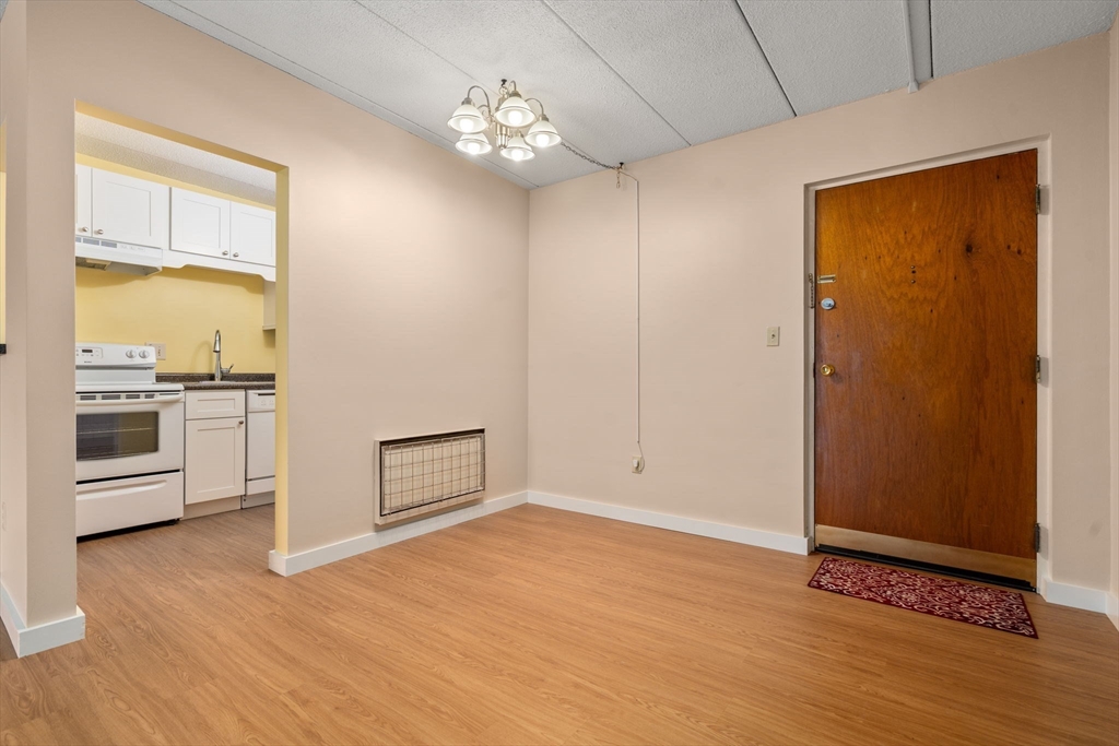 90 High Street, Unit 309 Dedham, MA 02026 - Photo 6 of 20 an empty room with wooden floor cabinet and windows
