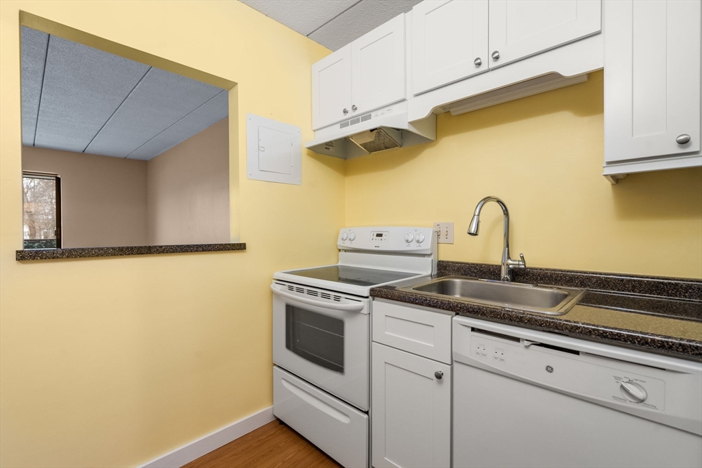 90 High Street, Unit 309 Dedham, MA 02026 - Photo 7 of 20 a close view of a stove a sink and cabinets
