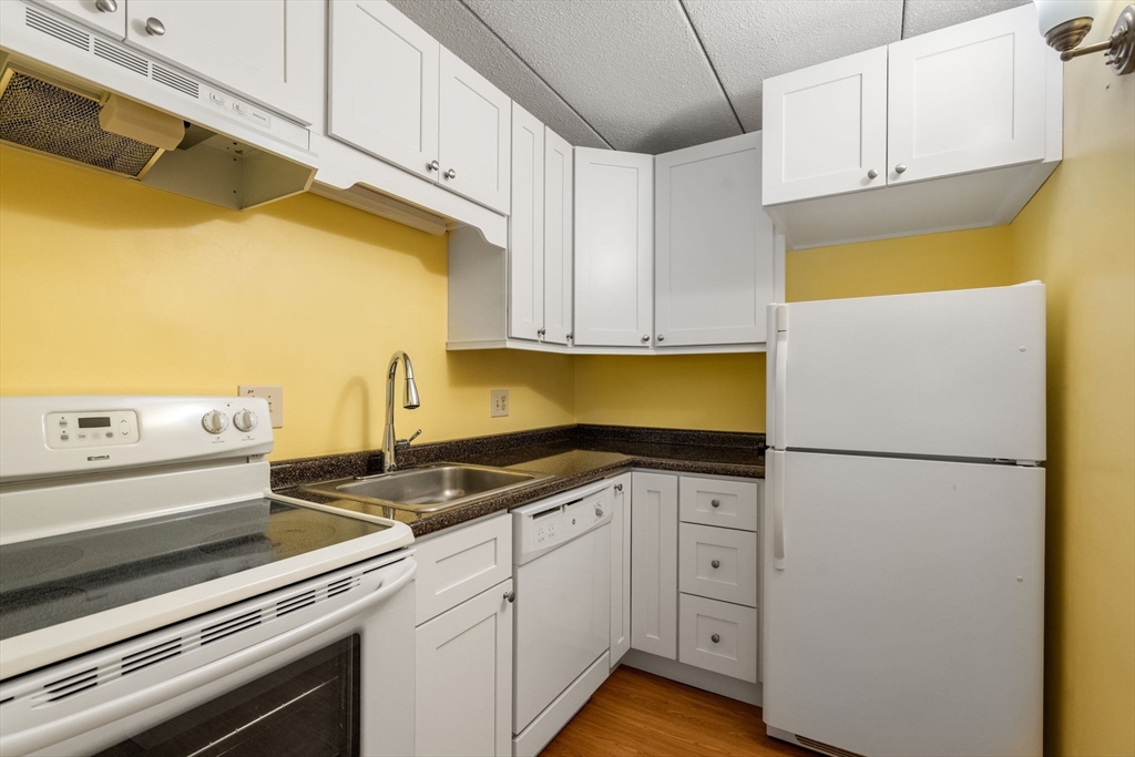 90 High Street, Unit 309 Dedham, MA 02026 - Photo 9 of 20 a kitchen with a sink and a refrigerator