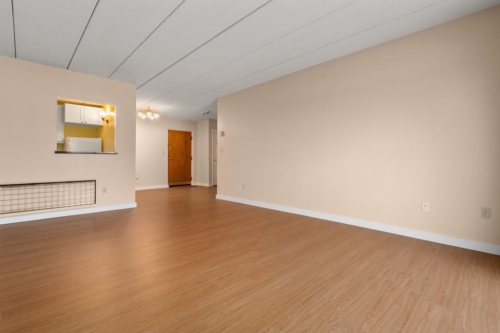 90 High Street, Unit 309 Dedham, MA 02026 - Photo 10 of 20 a view of an empty room with wooden floor and a window