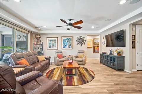 a living room with furniture a flat screen tv and a large window