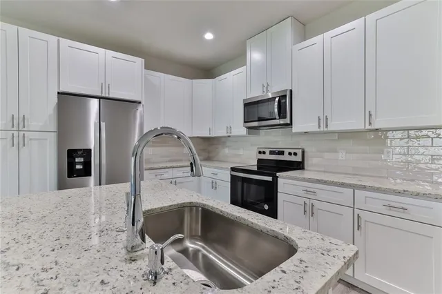 a kitchen with a sink cabinets and stainless steel appliances