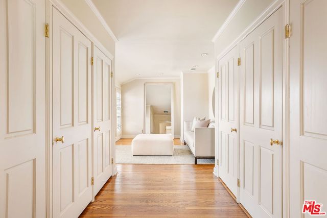 a hallway with white doors wooden floor and front door