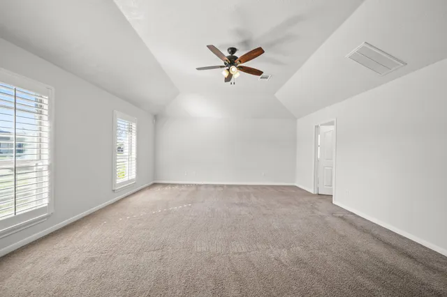 an empty room with windows and fan