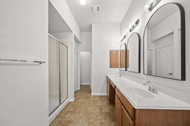 a bathroom with a double vanity sink mirror and