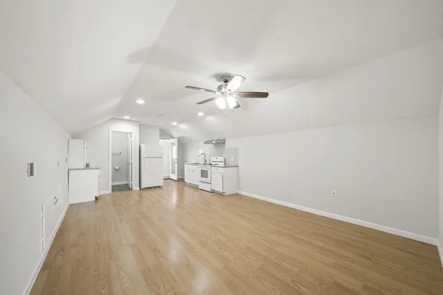 a view of a room with wooden floor and ceiling fan